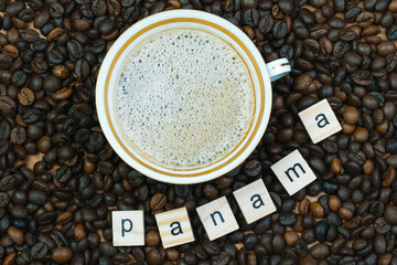 Top view of a cup of coffee on a background coffee beans with the inscription Panama. Country of...