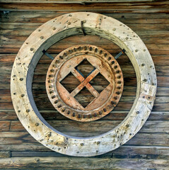 decoration  on a wooden wall with old wooden wheels of a former water mill