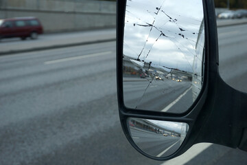 Close-up rear view mirror with lots of cracks. Bad luck, possible accident.