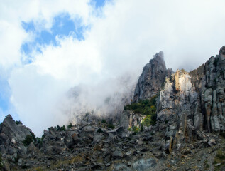 Landscape. Fabulous mountains rest against snow-white clouds.