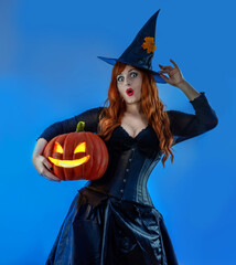 Halloween Witch Woman with long red hair and holiday make-up wearing dark tapered witch's hat