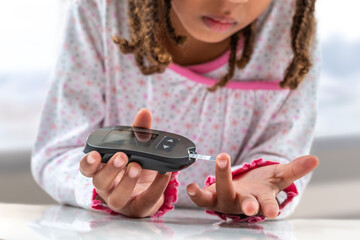 Children diabetes children with glucometer learning to check blood sugar level at home Learn to use...