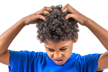 Smiling young boy scratching hair for head lice or allergies.