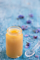 Organic royal jelly in a small bottle with flowers.