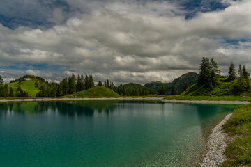 Nice blue green lake on big mountains in Austria summer cloudy day