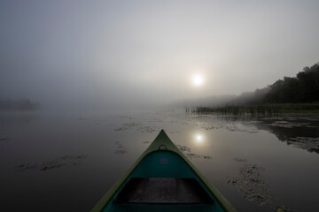 Mystical landscape at dawn. Early morning. Fog on the river. Beautiful dawn in the summer by the river. View from the boat to the morning landscape.