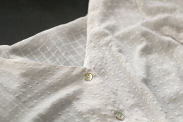 Detail of white cotton blouse. Selective focus.
