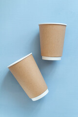 empty paper cup to go against light blue background