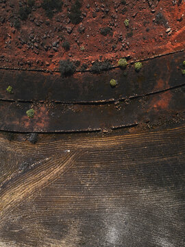 Aerial view of a cultivation on an arid lava soil with reddish, black and yellowish color contrasts in Tinajo, Lanzarote, Spain.