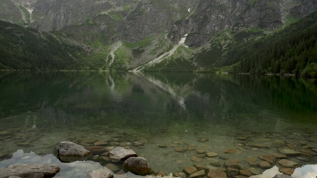 Tilt up shot of Morskie Oko Lake in cloudy weather located in Tatra Mountains at dawn, Zakopane, Poland, Europe