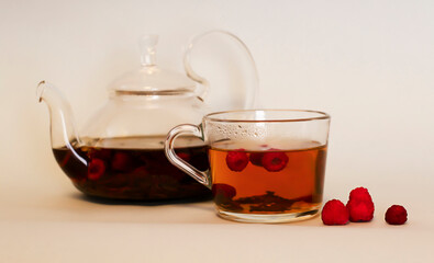 mug with hot raspberry tea and a teapot