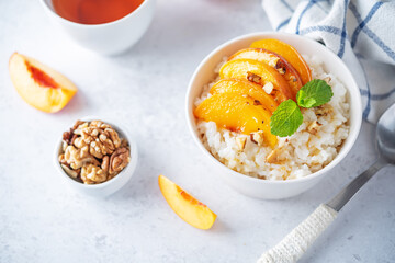 Sweet caramel rice porridge with caramelized peaches and walnuts in a bowl
