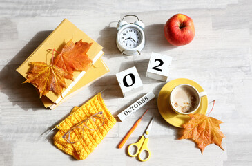 Calendar for October 2 : the name of the month in English, cubes with the numbers 0 and 2, books,...