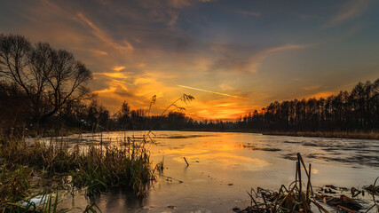winter evening landscape. view of the frozen lake under the dramatic sky after sunset