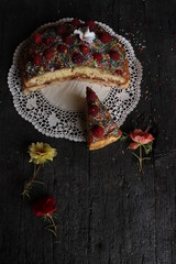 cake with vanilla top and caramel cream, decorated on a rustic black wooden table