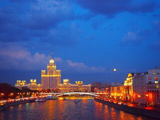 Fototapeta na wymiar evening view on the river, a residential skyscraper on Kotelnicheskaya Embankment, Moscow River, Bolshoy Ustinsky bridge. Moscow, Russia