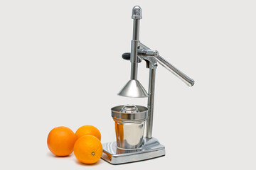 citrus metal juicer and oranges next to it