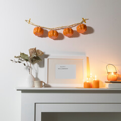 Preparing your home for Halloween. A garland of pumpkins on the wall above fake dresser panel....
