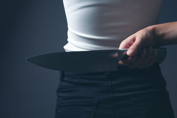 woman holding a knife from behind