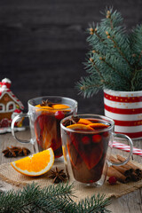 Christmas mulled red wine with spices and oranges on a wooden rustic table. Traditional hot drink at Christmas