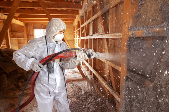 Insulation of a frame house. Spraying cellulose insulation on the wall.