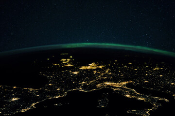 Night planet earth with the lights of megalopolis cities at night and the northern lights. Europe and the cities of Italy, France, Spain and Germany, view from space.
