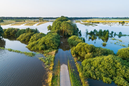 Aerial view of flooded floodplains of river Maas with submerged road during a period of high water in summer, Megen, Noord-Brabant, The Netherlands.