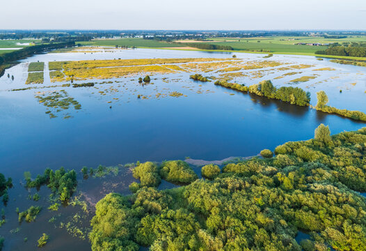 Aerial view of flooded floodplains of river Maas with submerged road during a period of high water in summer, Megen, Noord-Brabant, The Netherlands.