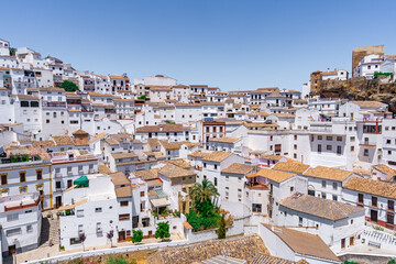 Fototapeta na wymiar Setenil de las bodegas, pueblo rústico con casas blancas tradicionales de pueblo construidas en una ladera unas sobre otras como una pared de casas,, en la provincia de Cádiz, Andalucía, España.