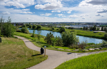 A storm retention pond creates natural habitat in a new urban community with bike paths in Airdrie Alberta Canada.