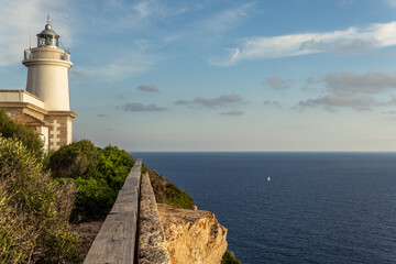 Cap Blanc lighthouse on the rocky coast of the island of Mallorca. In the background s seascape of...