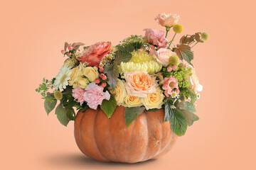 Bouquet of autumn flowers collected in a pumpkin. Floristry for Halloween.