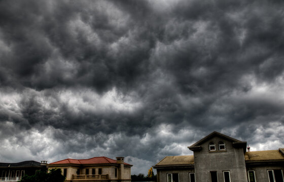 Closeup shot of houses under the sky, with many gray clouds