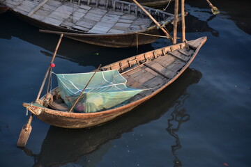 Fototapeta na wymiar バングラデシュのダッカ。 川に浮かぶ小船。 船上に蚊帳を張り眠る男性。