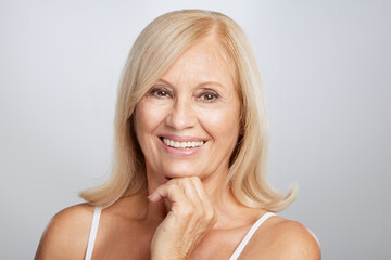 Portrait of beautiful blond senior woman posing and looking at the camera. Beauty photography