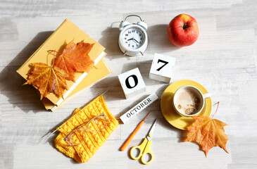Calendar for October 7 : the name of the month in English, cubes with the numbers 0 and 7, books,...
