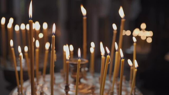 The theme of religion, faith, Christianity, God and the Orthodox Church. A close-up of much waxed candles are burning in a candlestick. Religious concept.