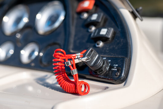 CROW WING CO, MN - 23 AUG 2021: Closeup of pontoon ingnition key for a Yamaha outboard boat motor, with red plastic coiled cord and blurred instrument console.