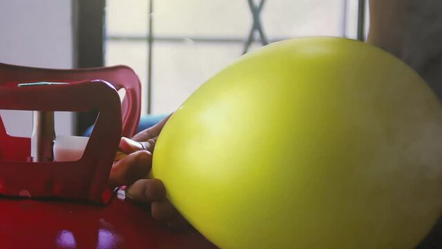 Yellow Balloon being filled up by a Helium Tank. Close-Up. Zoom In. 4K Resolution.