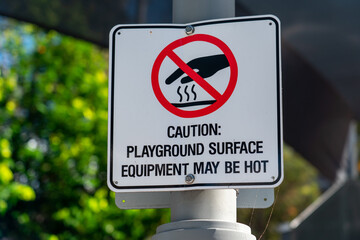 Caution: Playground surface equipment may be hot sign