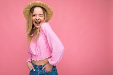 Beautiful young blonde woman smiling and having fun standing isolated over pink wall keeping hands...