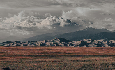 Beautiful view of Great Sand Dunes National Park in Colorado, with grassy plains, sand dunes, and...
