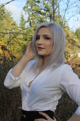 portrait of a silver haired lady with bright trees in background 