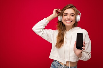 Beautiful happy smiling young woman wearing stylish casual outfit isolated on background wall...