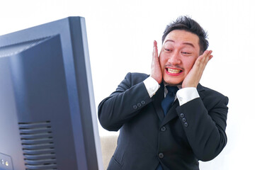 パソコンを見て驚くビジネスマン