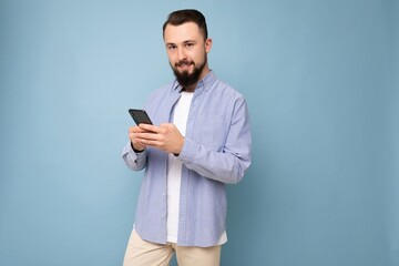 handsome young brunette unshaven man with beard wearing stylish white t-shirt and blue shirt...