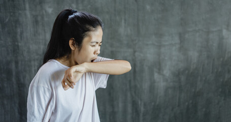 Fototapeta na wymiar Asian woman arm covering mouth and nose while coughing with copy space 