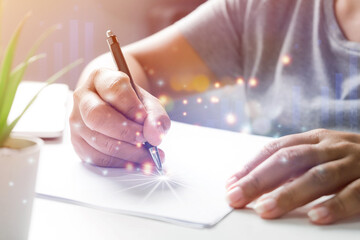 Woman hand writing on paper on table, Close up, writing on paper the business concept.