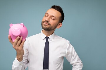 Portrait photo of positive self-confident young handsome brunet unshaven male businessman with beard with sincere emotions wearing casual white shirt and tie isolated over blue background with copy