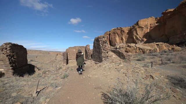Woman With Photo Camera Walking on Trail Between Ruins of Pueblo, Chaco Culture National Historical Park, New Mexico USA, Panorama
